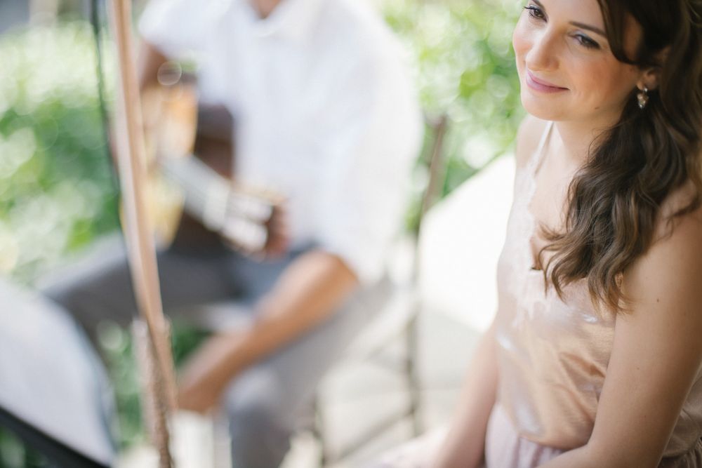 Soft focus side view of person in white dress seated outdoors.