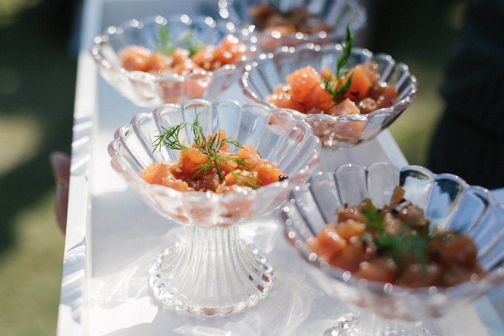 Crystal dessert cups filled with fresh salmon and garnished with herbs.