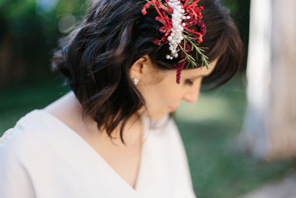 Side profile view showing red floral hair accessories against dark hair.