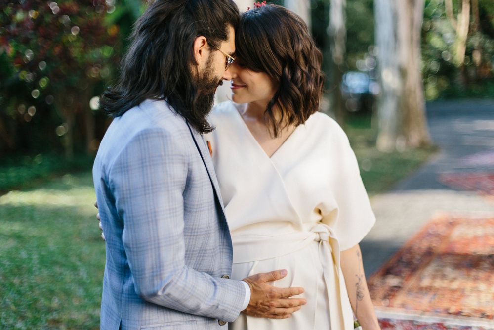 A couple in wedding attire shares an intimate moment in an outdoor garden setting.