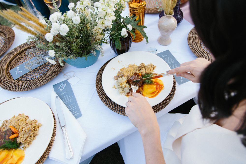 Overhead view of an elegant table setting with plated food and floral centerpiece.