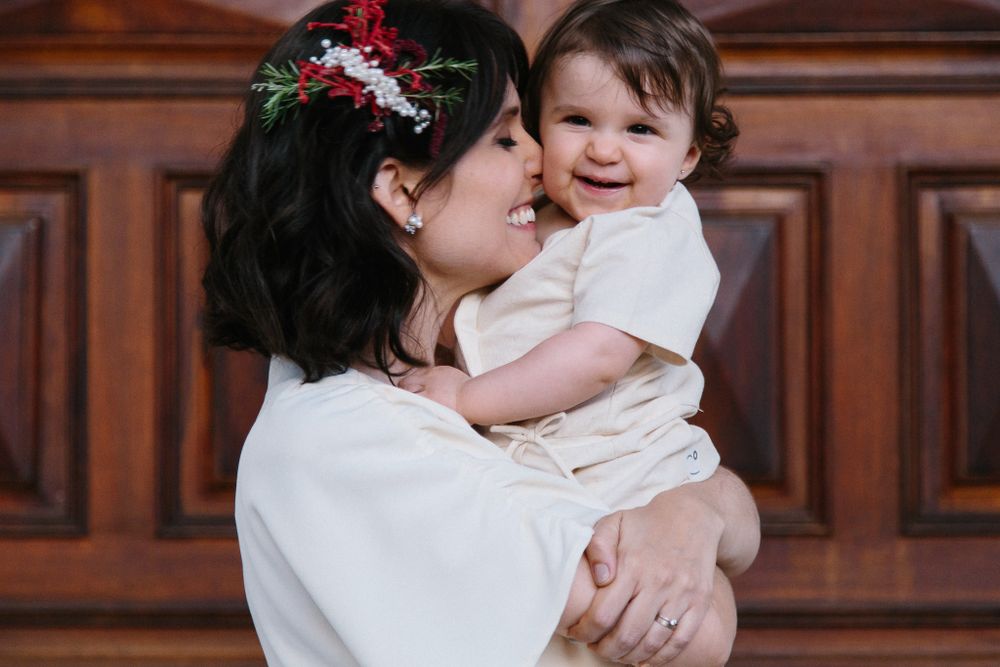 A tender moment shared between parent and child against wooden paneled background.