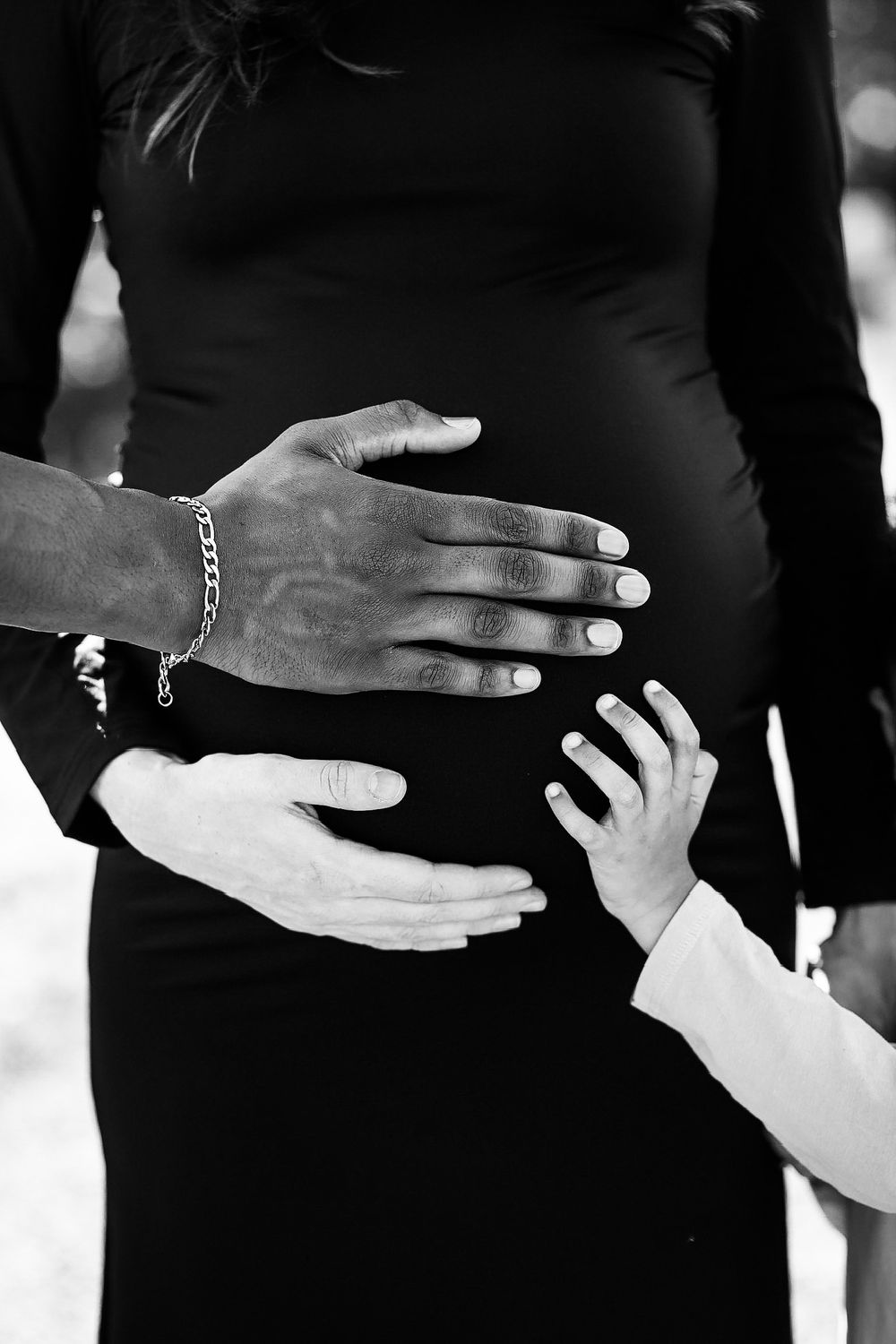 Black and white series of hand silhouettes reaching and connecting against dark background.