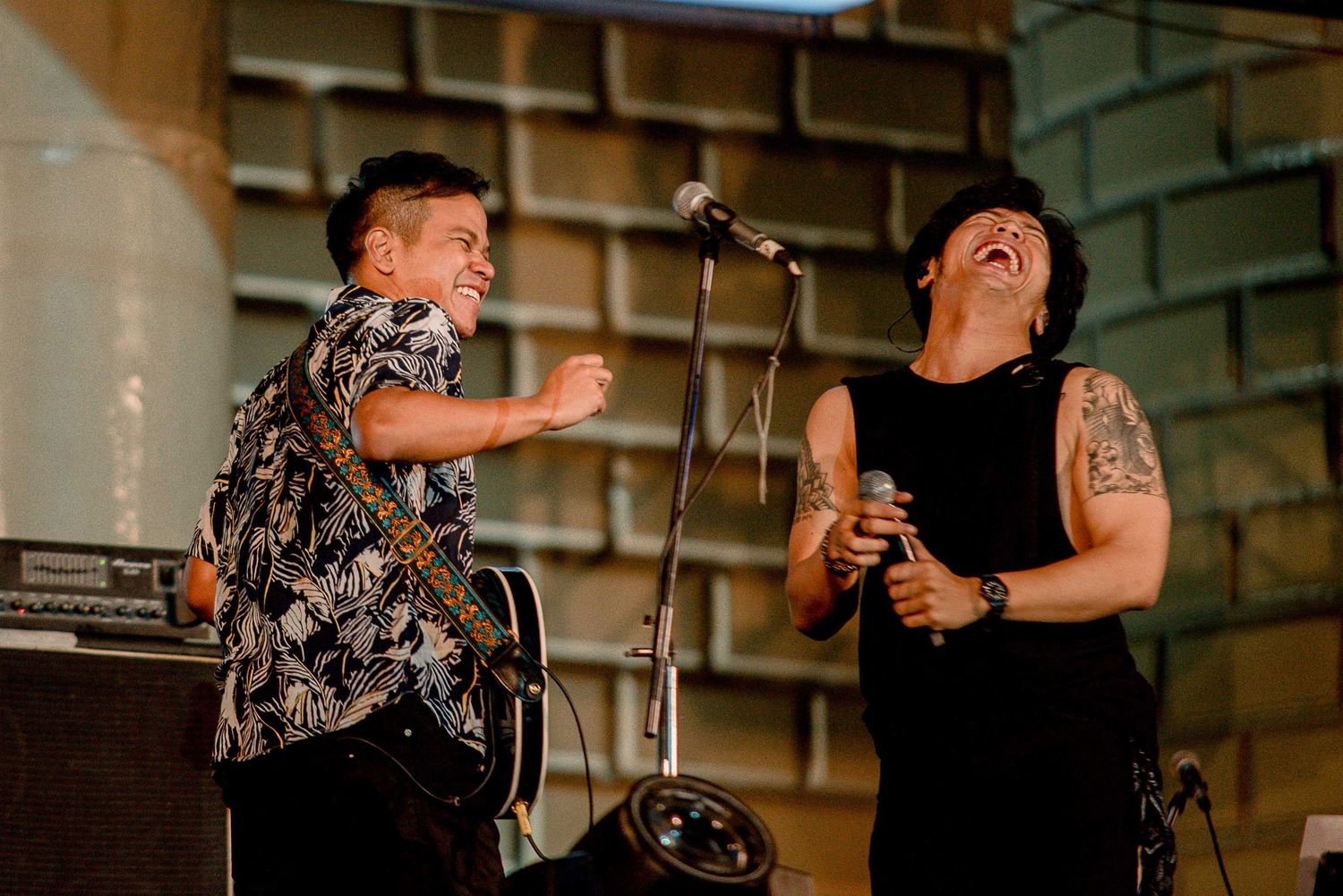 Musicians performing energetically on stage with microphone and instruments.