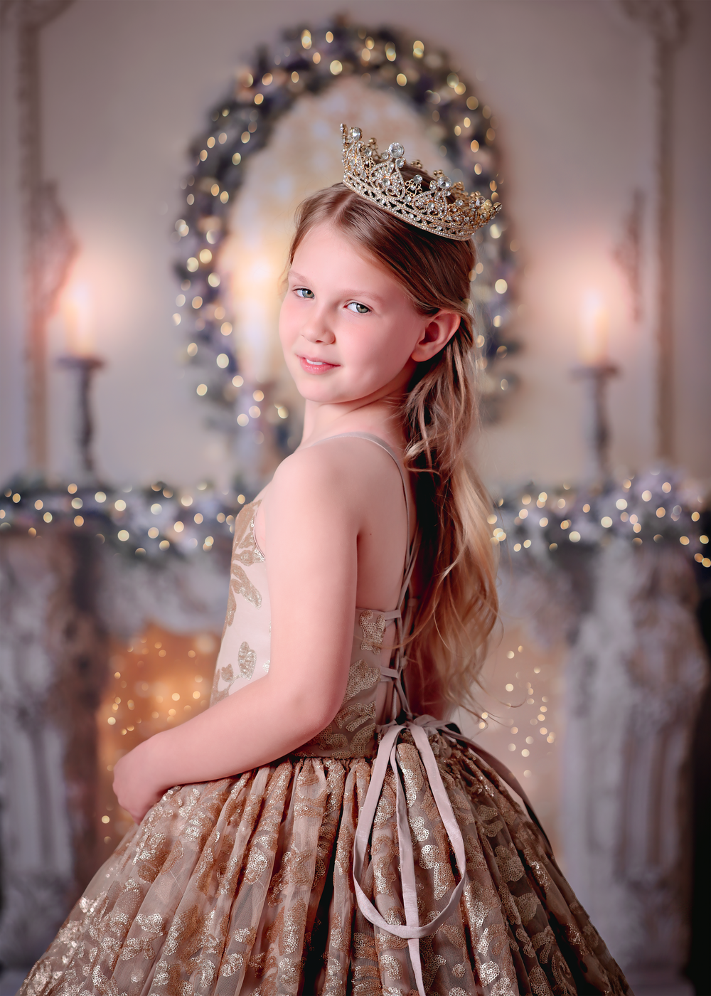 Girl in Gold sequin gown looking over shoulder in front of golden styled Christmas fireplace for a Dream Dress session