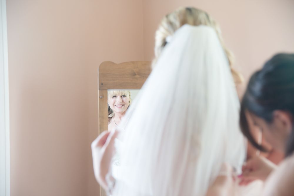 Wedding preparation scene with veil and mirror reflection.