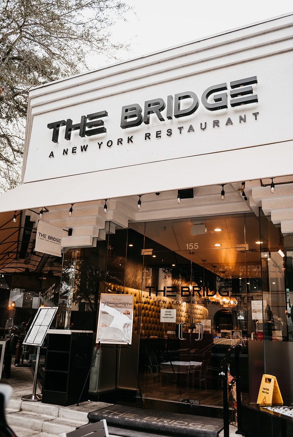 Exterior storefront of The Bridge New York Restaurant with modern signage.
