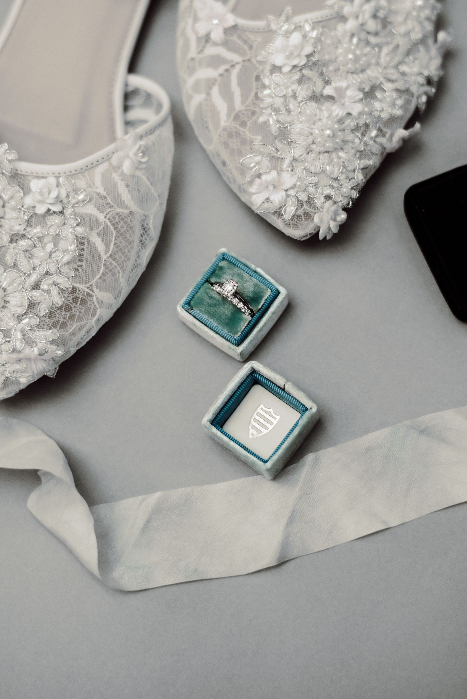Flat lay image of shoes and ring.