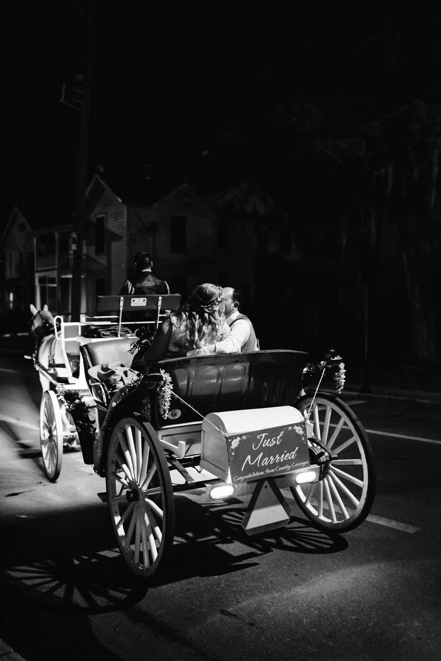 Bride and groom in horse drawn carriage.