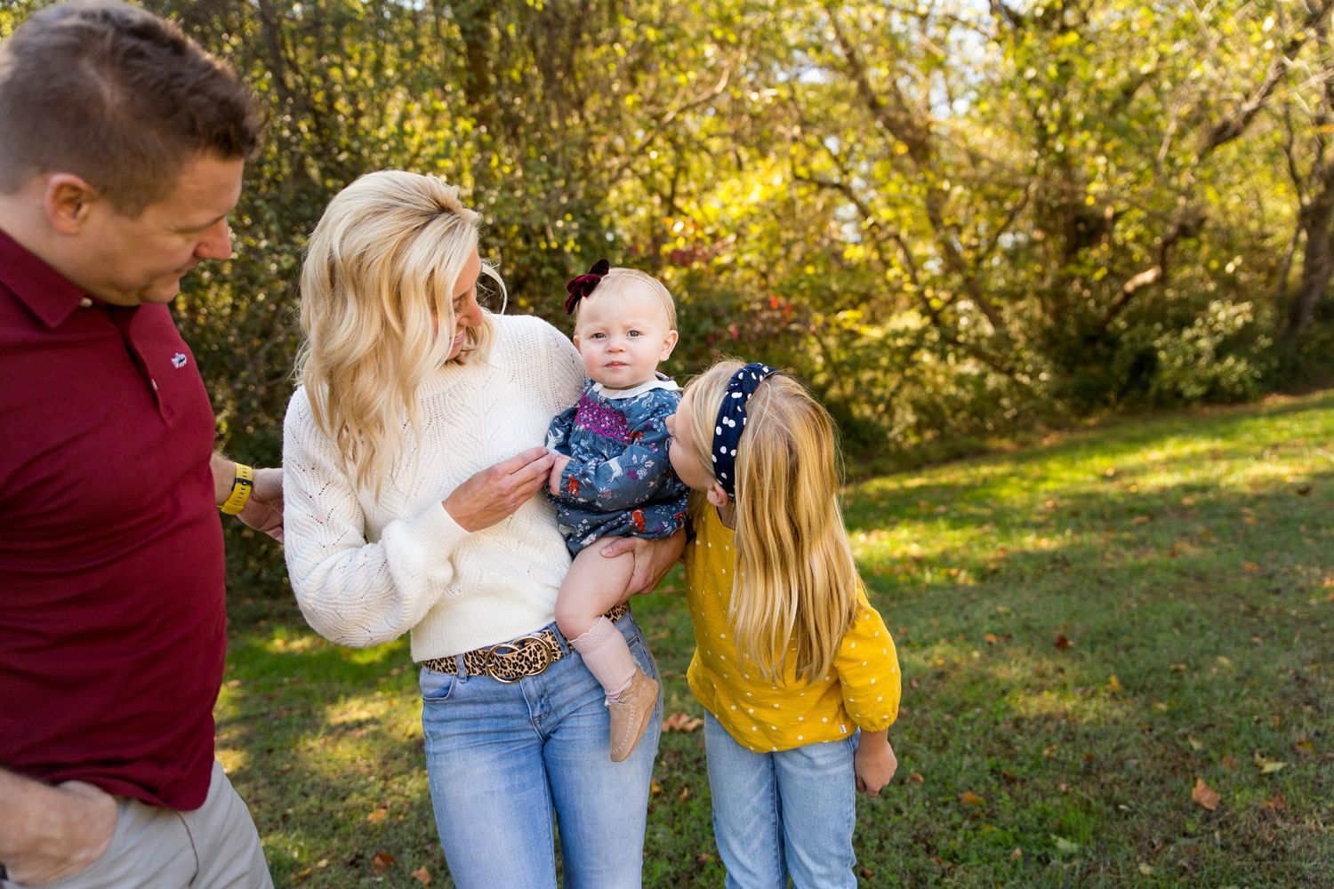 A family of 4 smiling at the youngest child