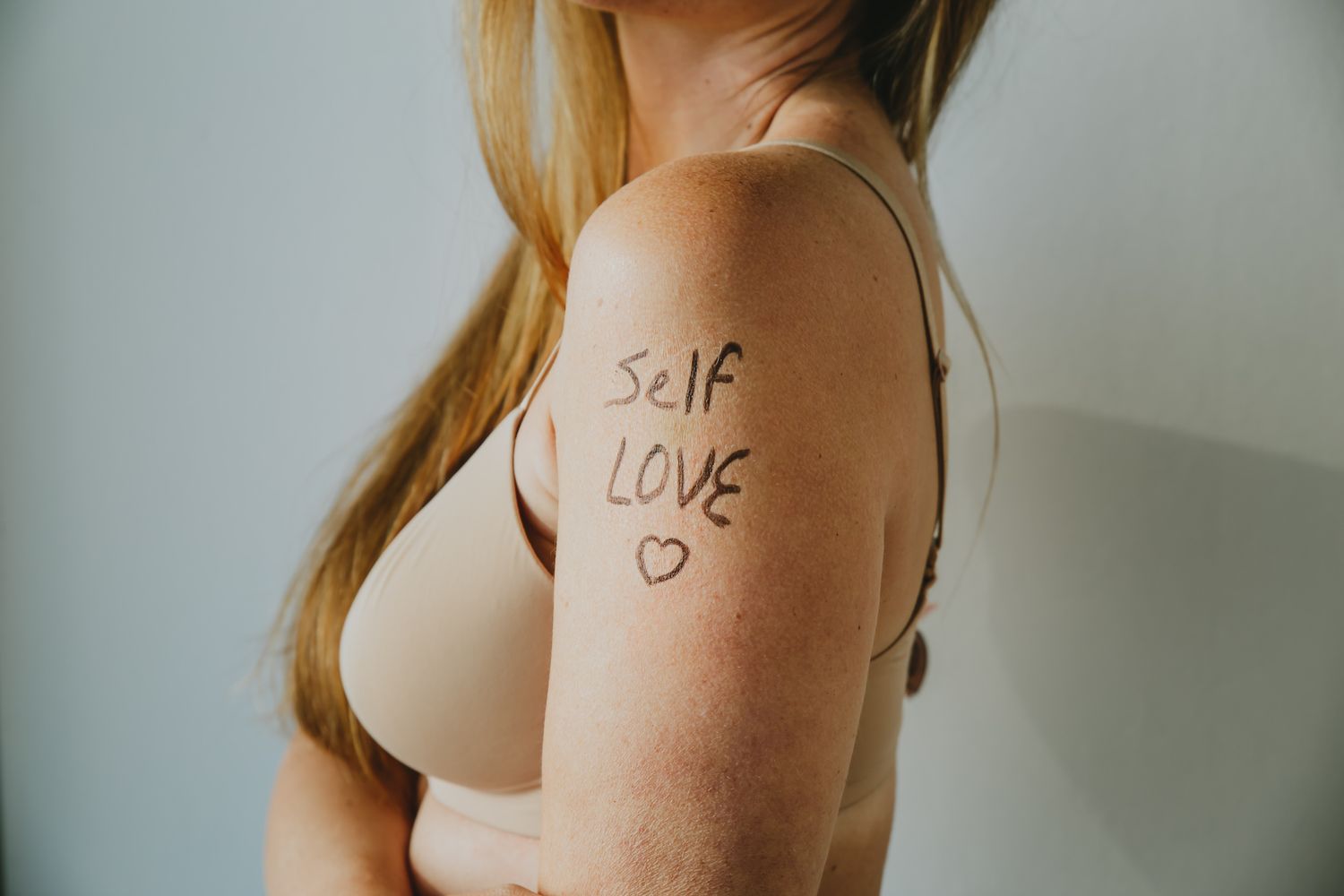 Influencer with the words "embrace your age" written on her arm