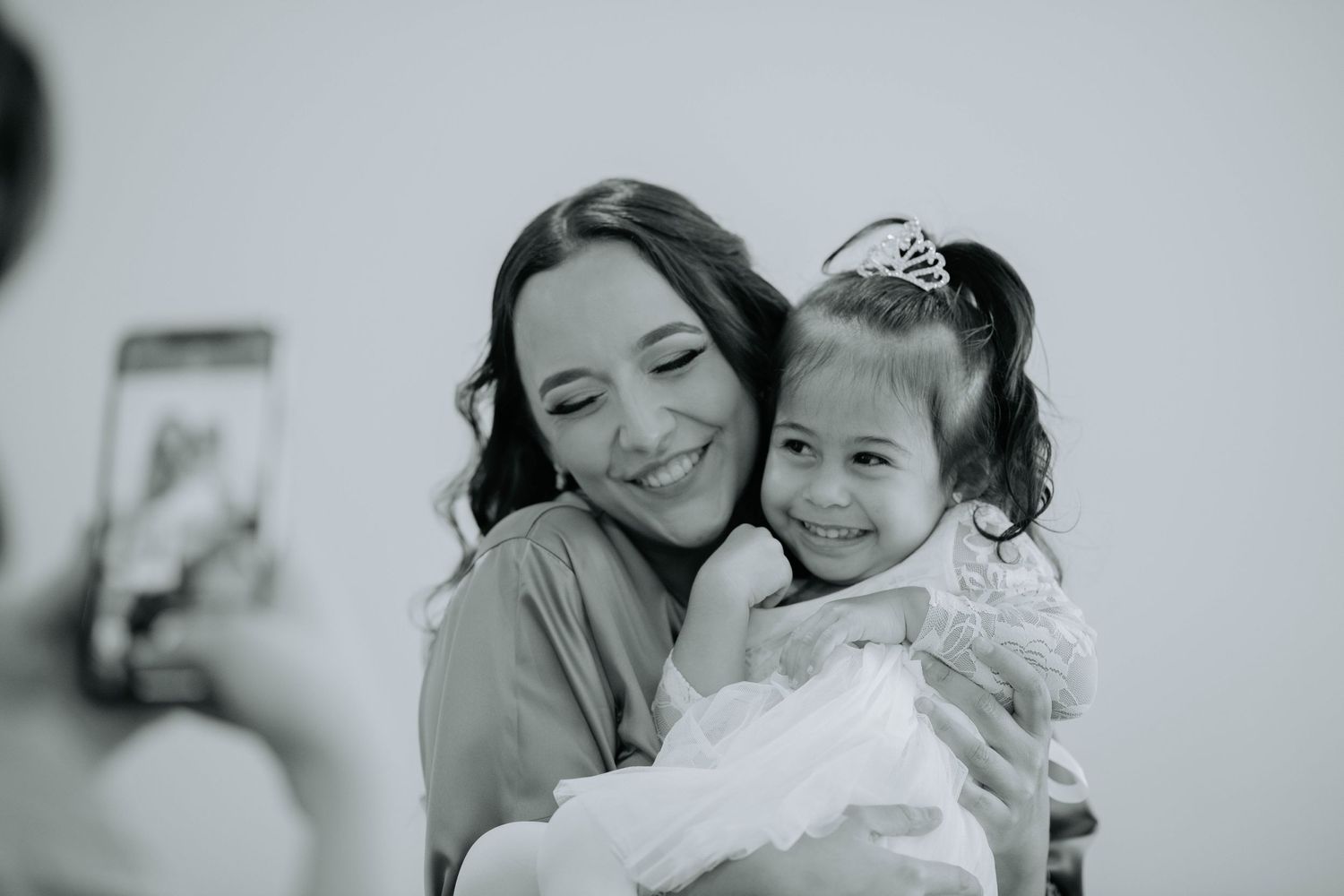A black and white candid moment capturing laughter and joy between a parent and child.