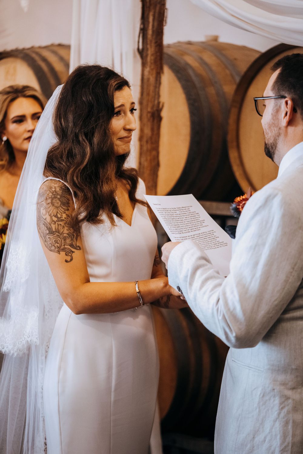 Close-up of couple during wedding ceremony vows in wine cellar setting.