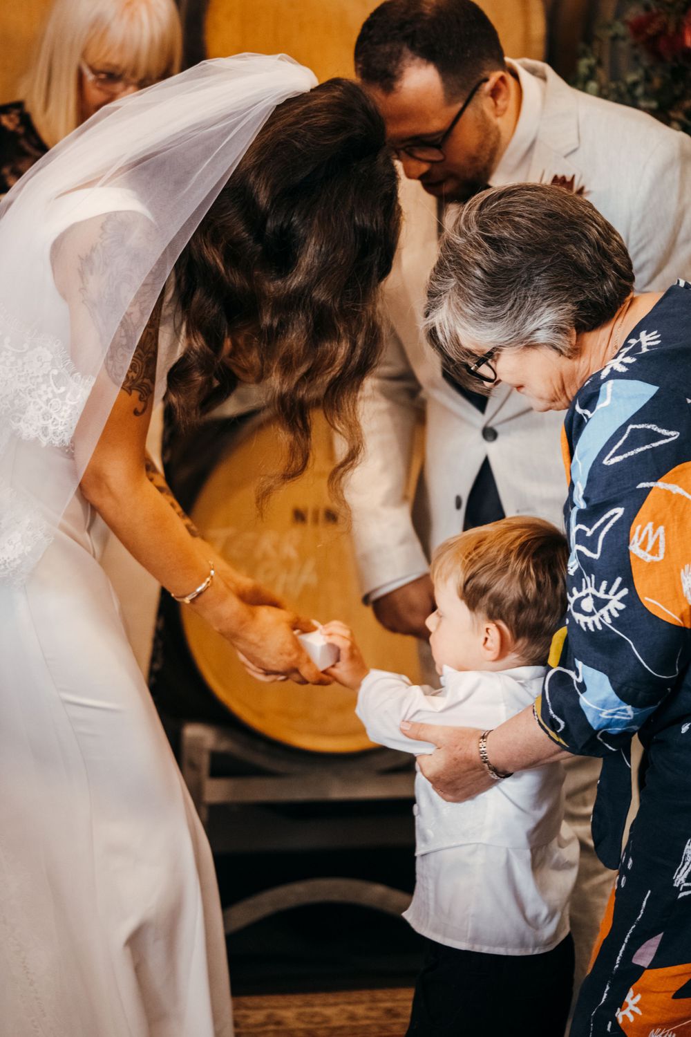 A documentary-style sequence of a wedding ceremony ring exchange in an intimate indoor setting.