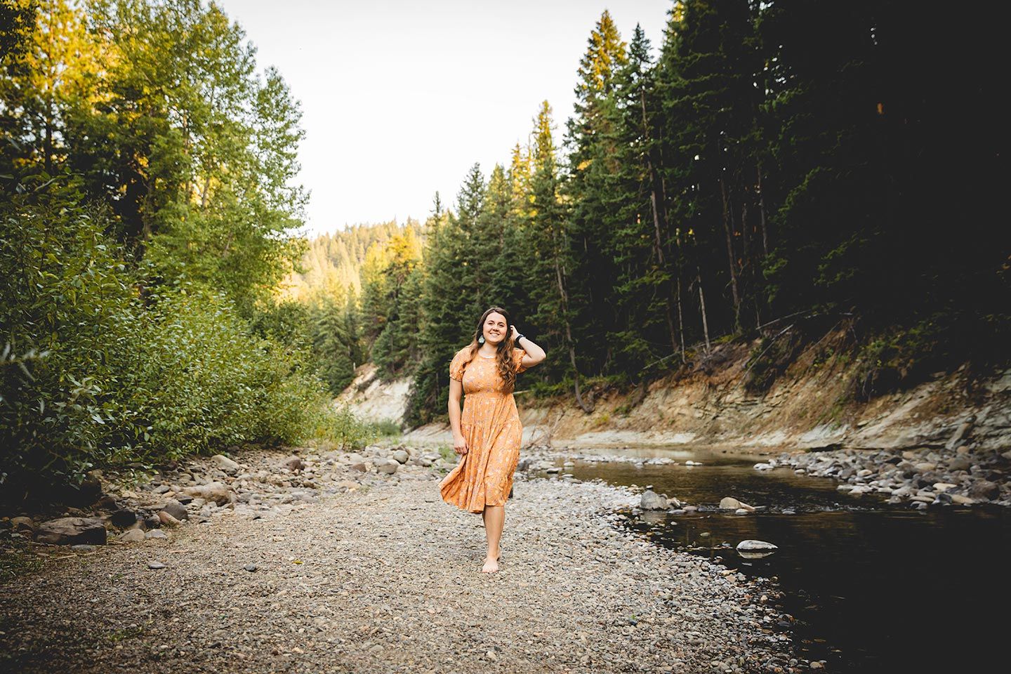 senior girl walking along the teannaway river near ellensburg