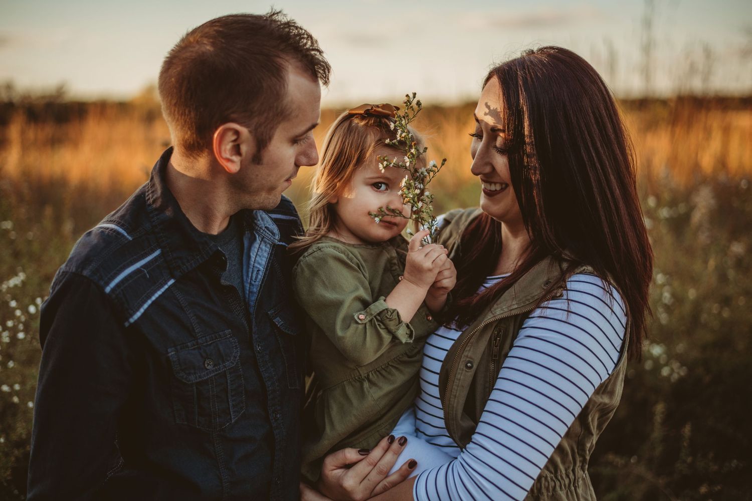 couple and their daughter squeeze together for fall photos