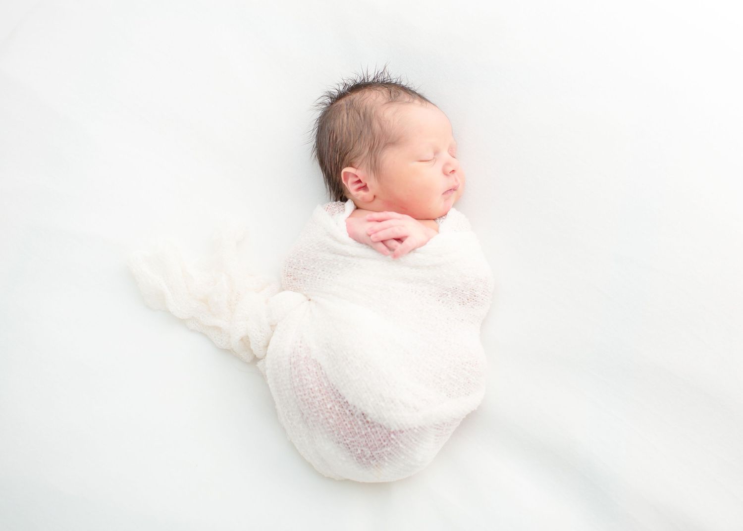 airy and dreamy photo of a newborn baby boy during a newborn all white theme photo session in houston