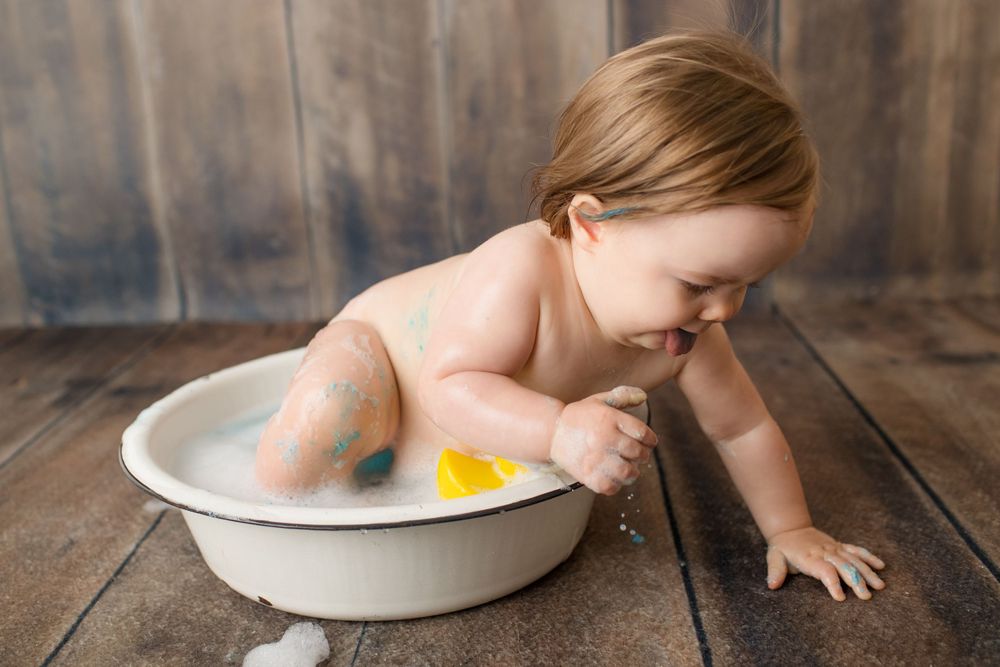 Bath time with yellow rubber duck in vintage white basin.
