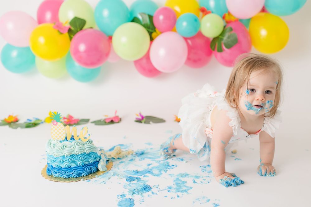Playful cake smash aftermath with blue frosting everywhere.