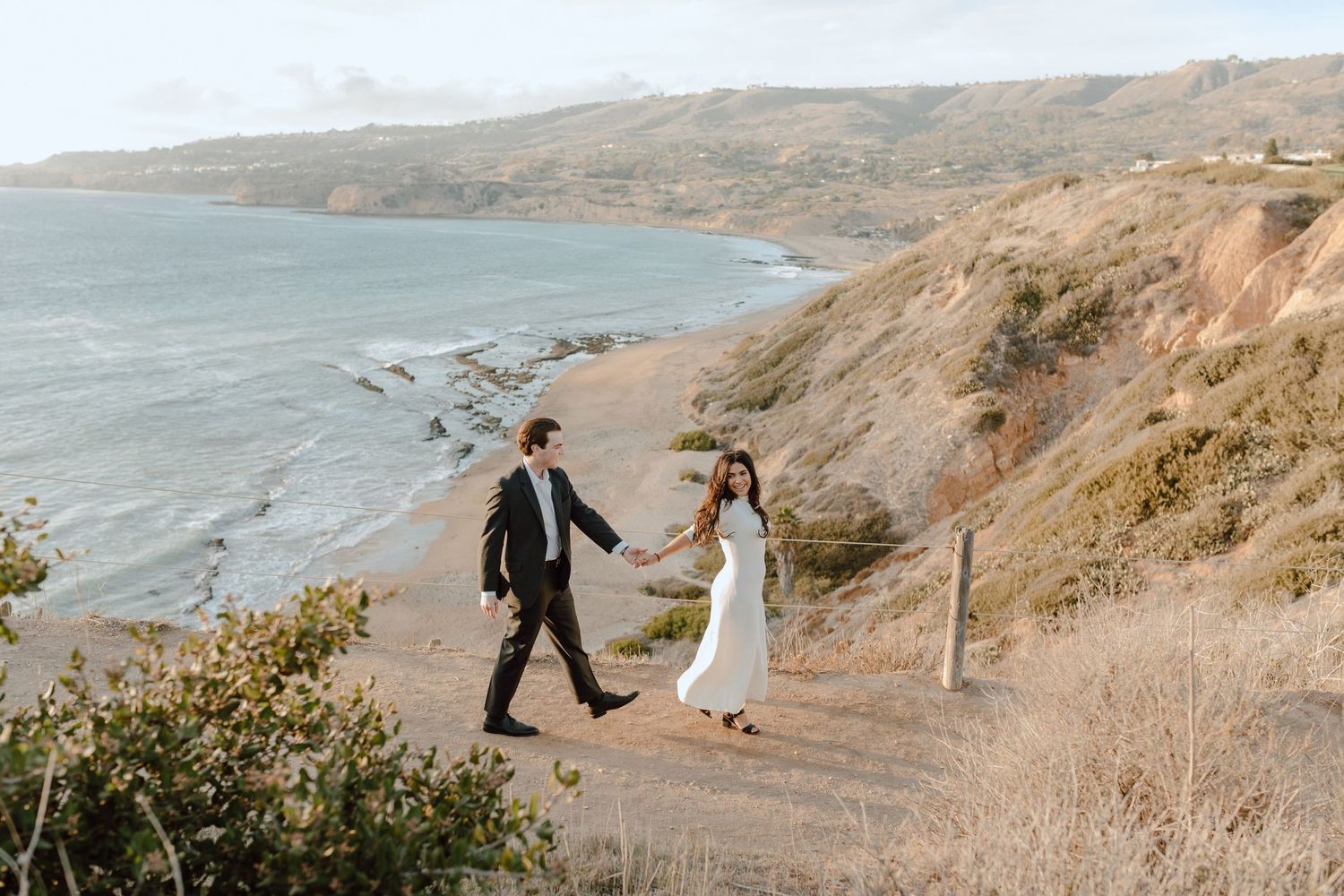 Bay Area Engagement Photographer. Engagement session of couple walking together on beach with cliffs in background.
