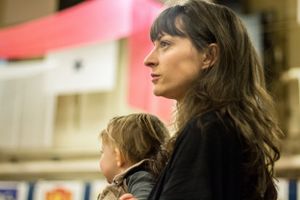 A mother and her daughter patiently await the return of their beloved soldier, their faces filled with anticipation