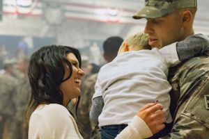 A heartwarming scene of a family reuniting after a deployment, embracing with love and joy, their faces filled with reli