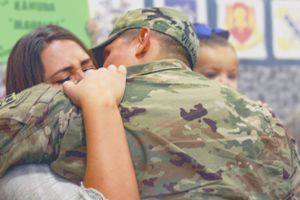 A heartwarming scene of a family reuniting after a deployment, embracing with love and joy, their faces filled with reli