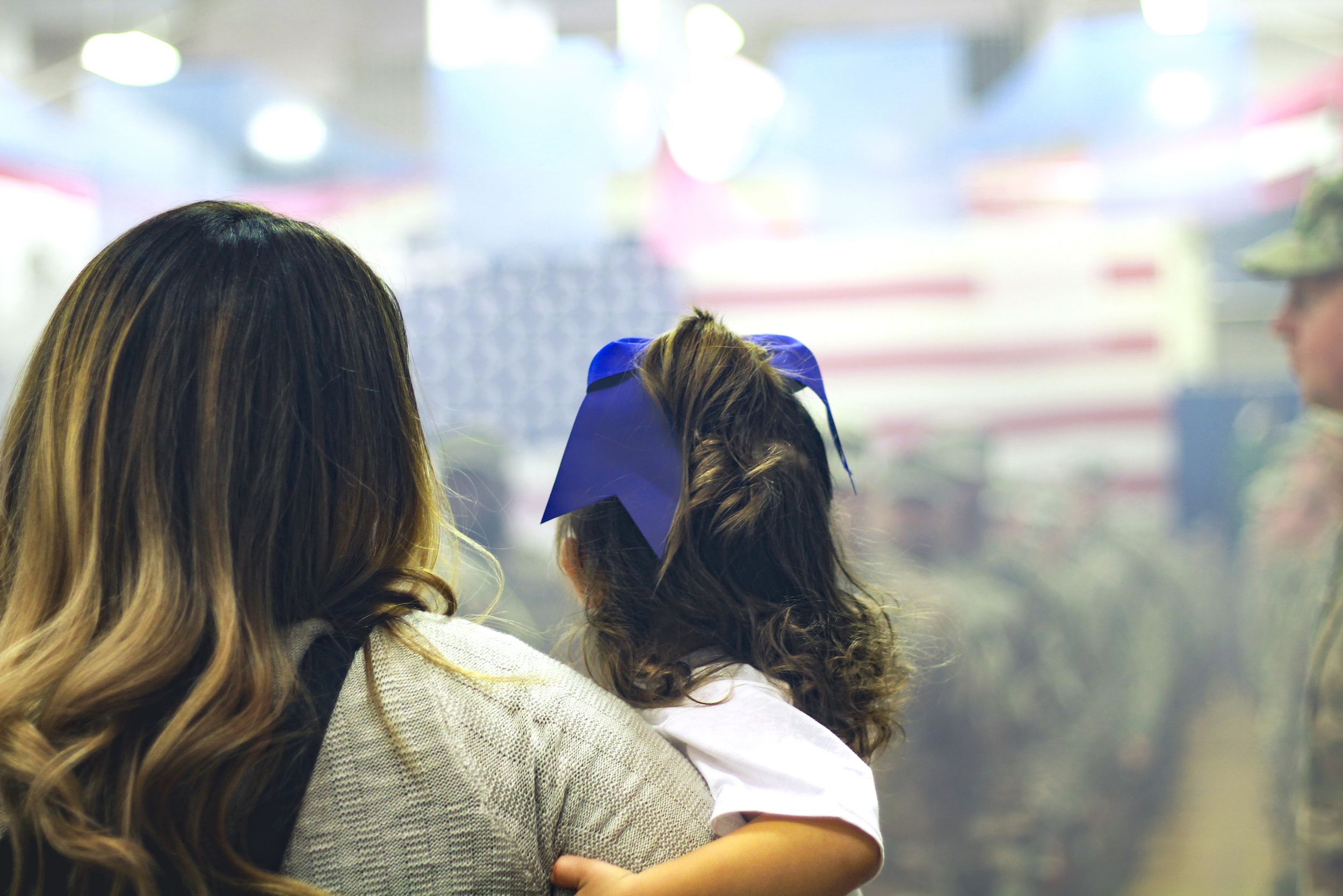 A mother and her daughter eagerly waiting for the return of their husband and father from a deployment