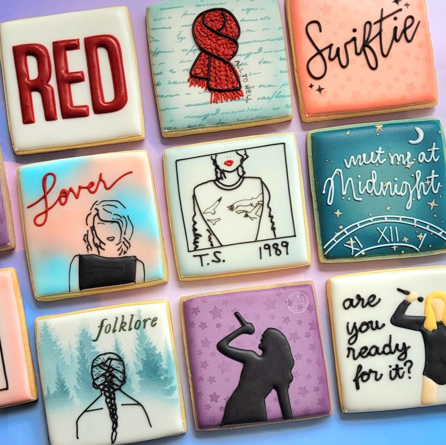 Decorated square sugar cookies with a Taylor Swift theme of various album covers.