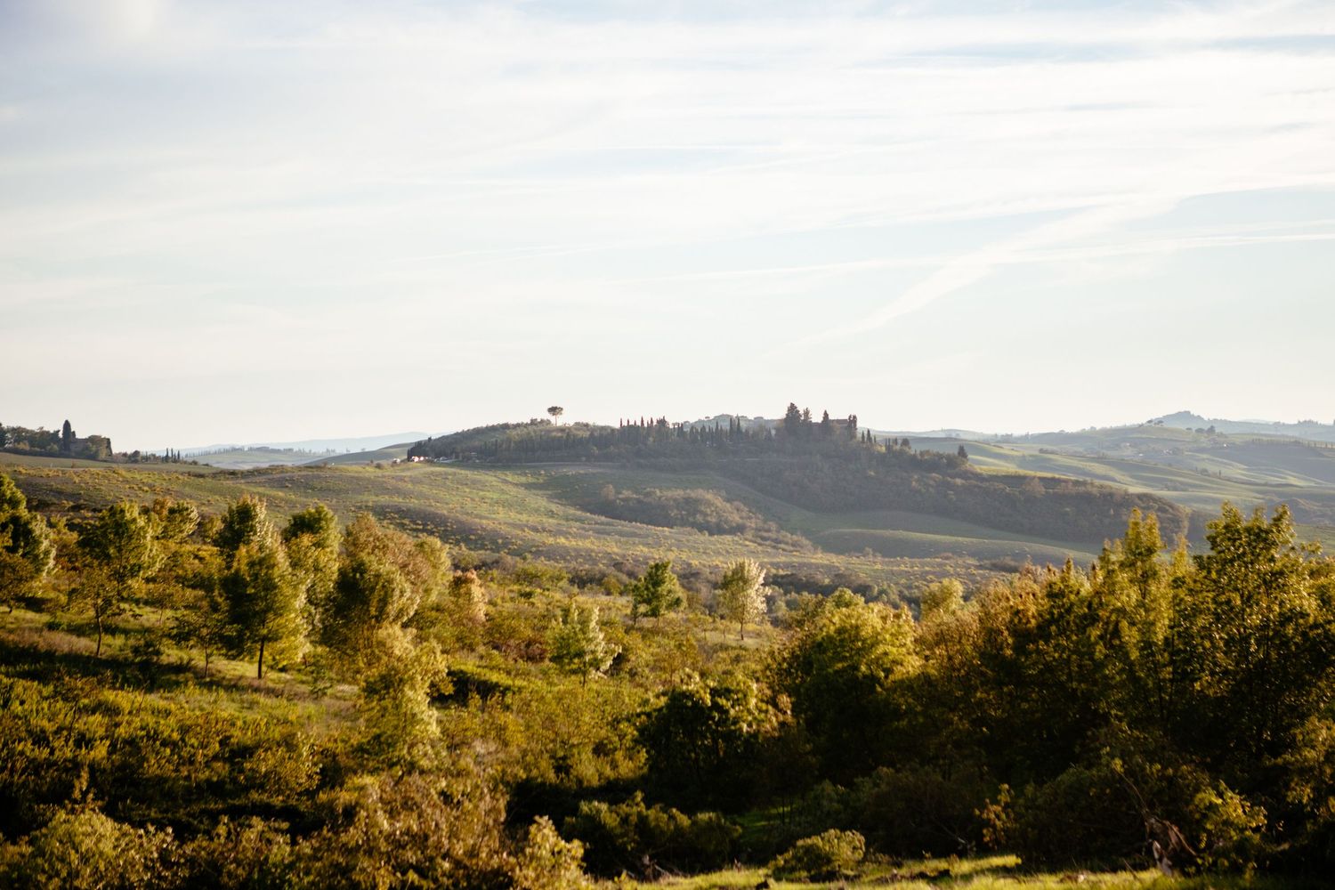 The Lazy Olive wedding venue pictured at a distance in the hazy light of the Siena region.