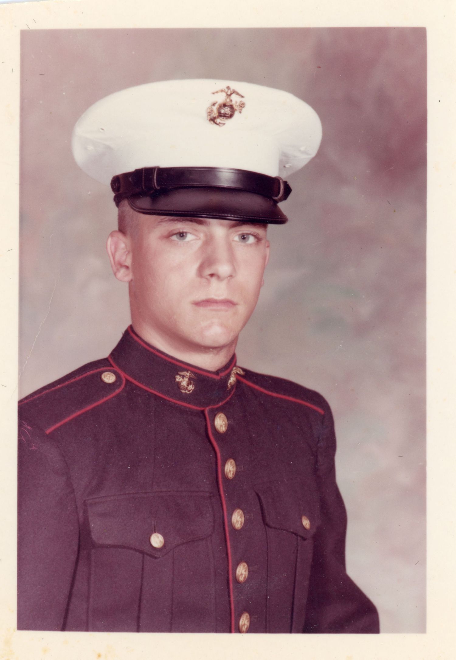 Portrait of a United States Marine in dress uniform with white cap.