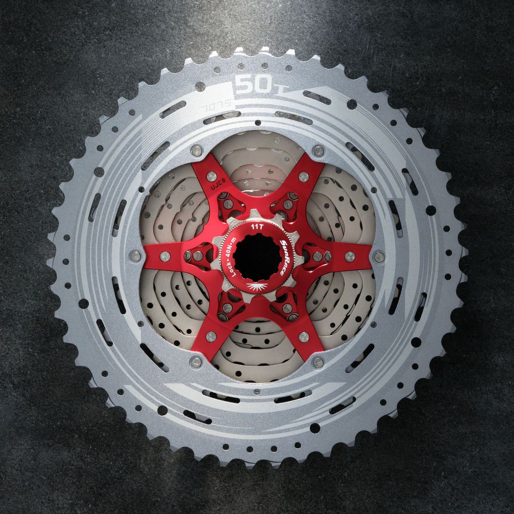 Sunrace MX80 (11 speed) 11-50T bicycle cassette lay on a concrete slab and lit up in a shaft of strong light.