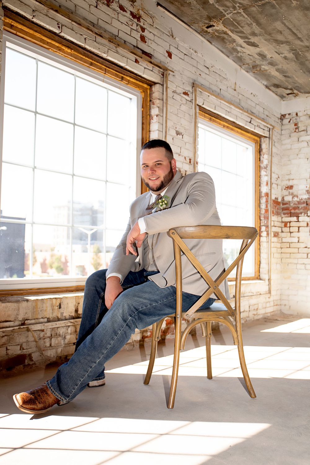 Casual portrait in industrial loft space with exposed brick and bright windows.