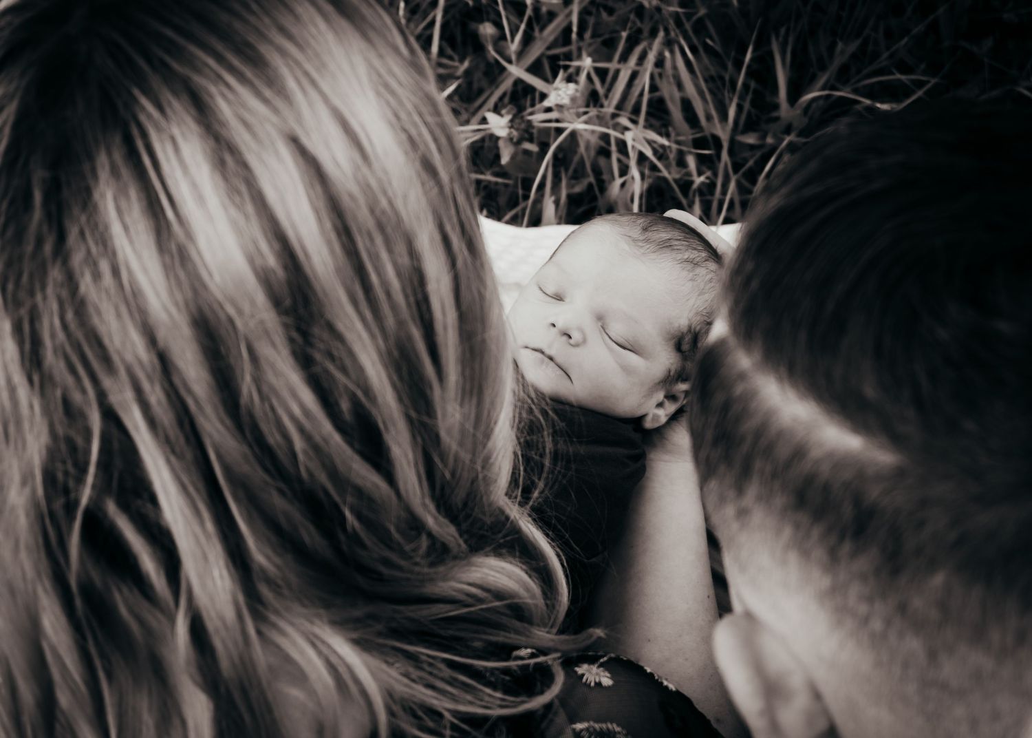 newborn snuggled by parents during photoshoot