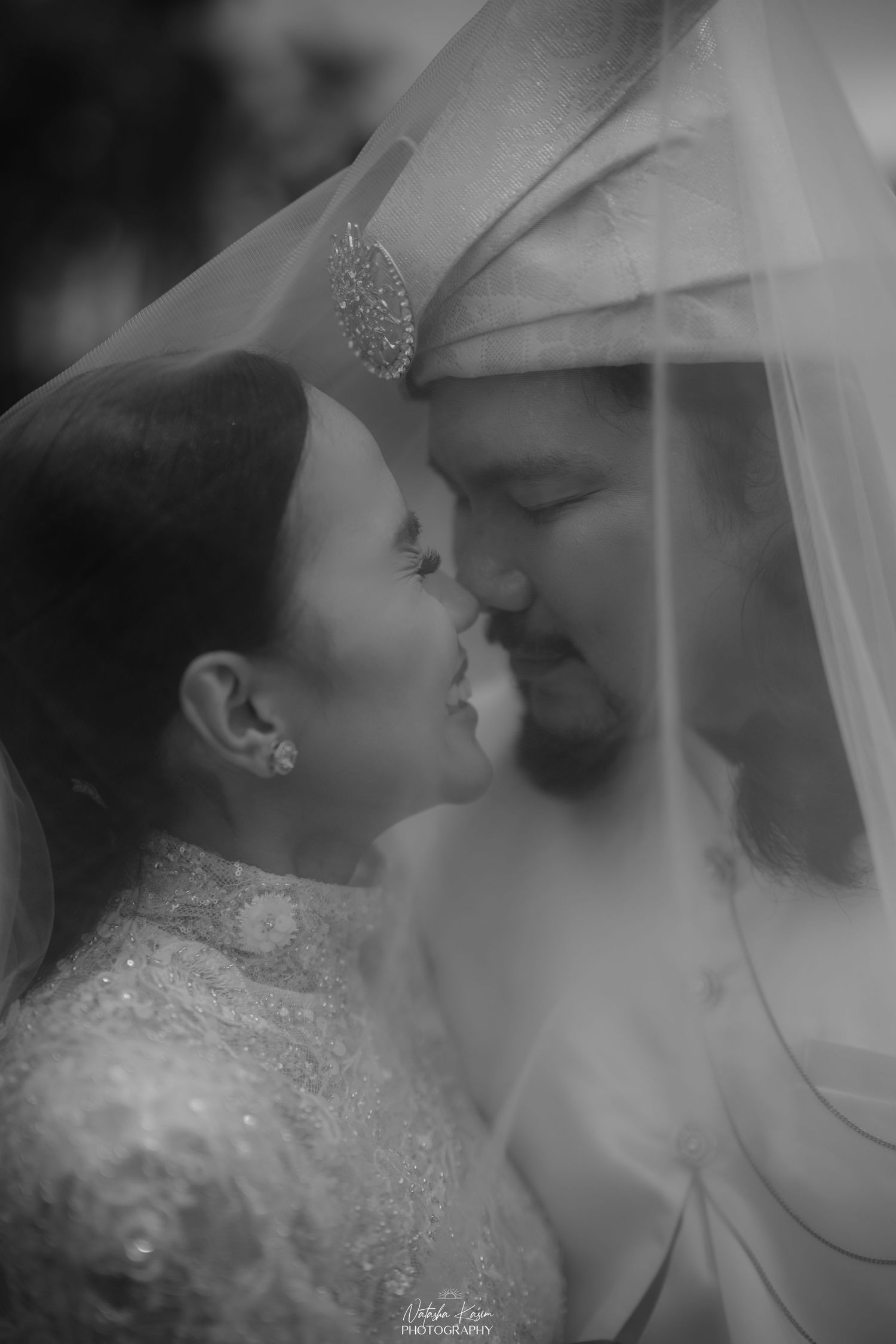 Romantic black and white wedding photograph with soft veil details.