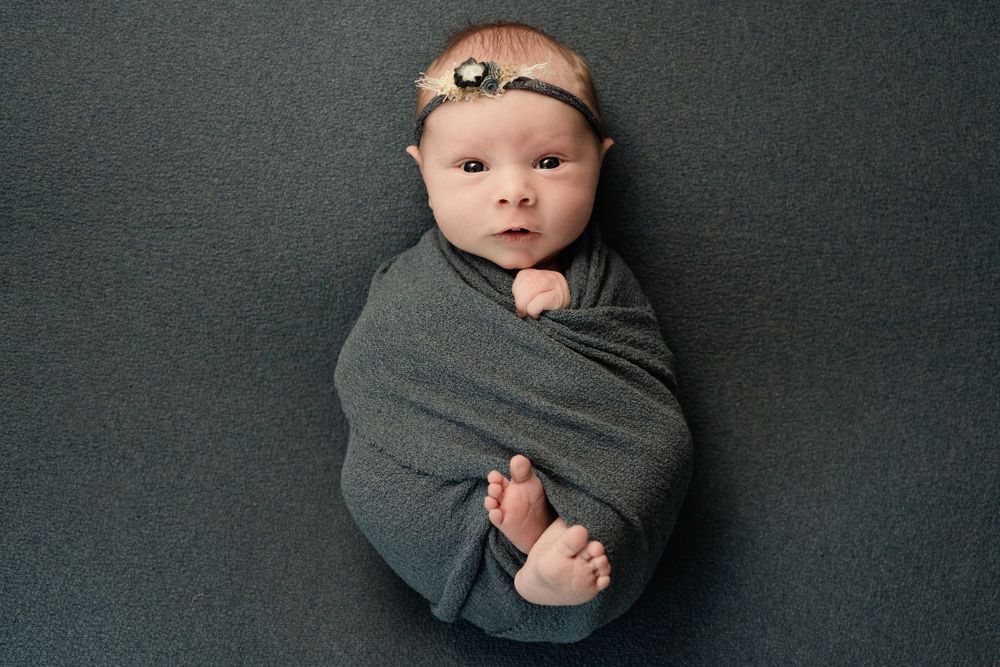 A Lisa Liberati Photography newborn baby photo wrapped up with a cute headband.