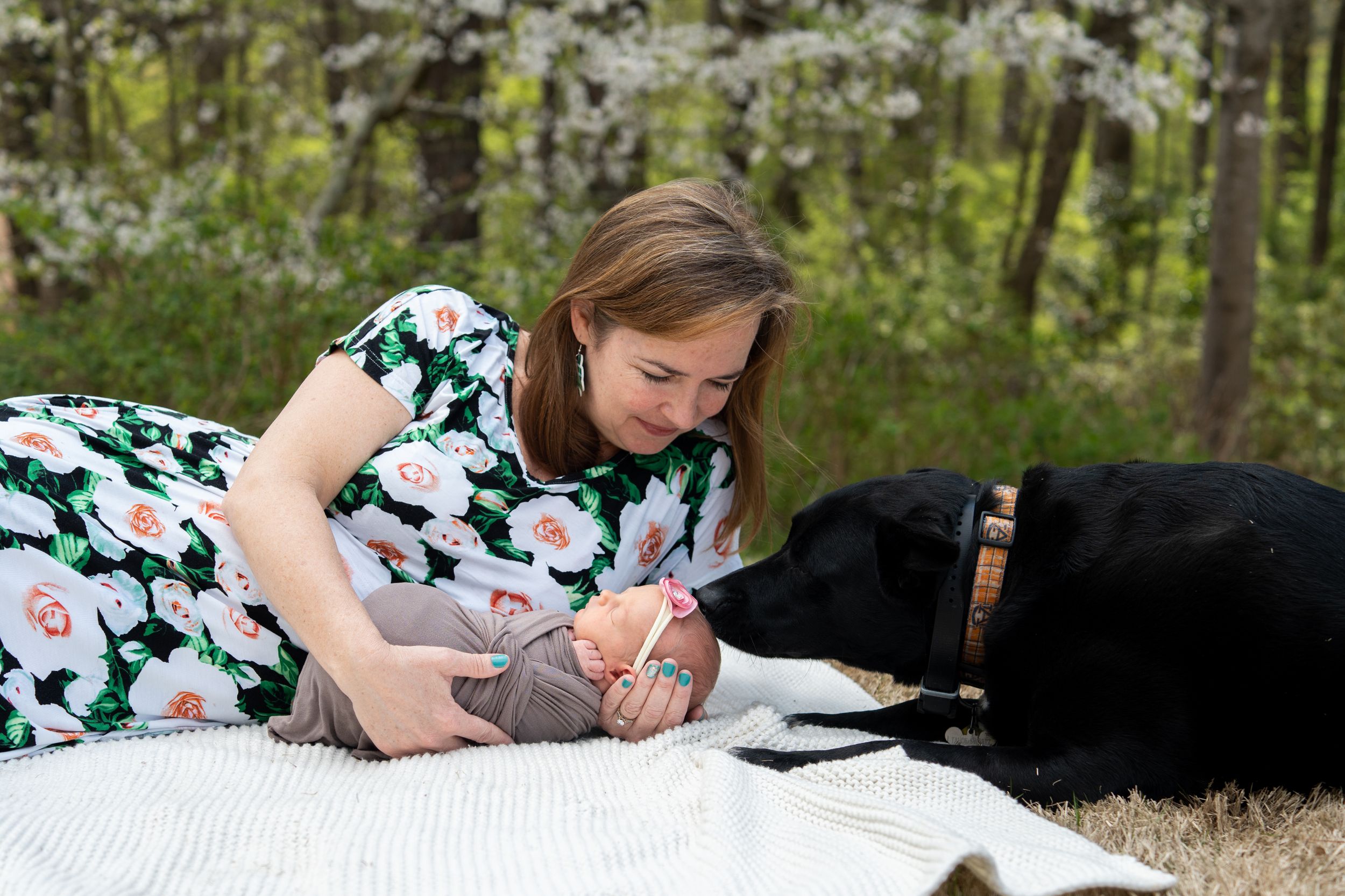 A Lisa Liberati Photography newborn photo of a mom and a baby laying on the ground.