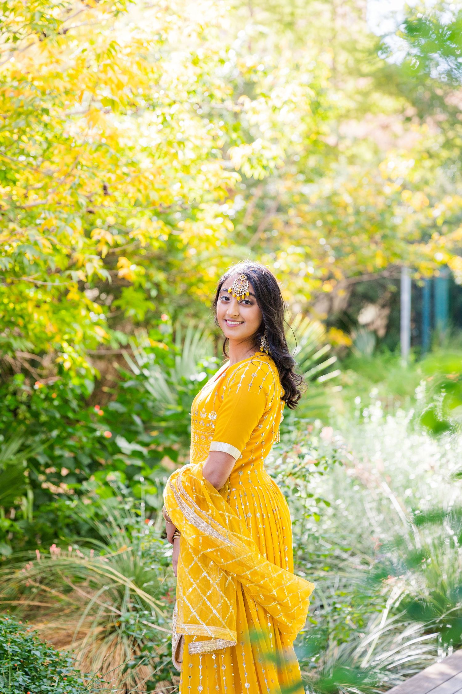woman in a sari standing in forest
