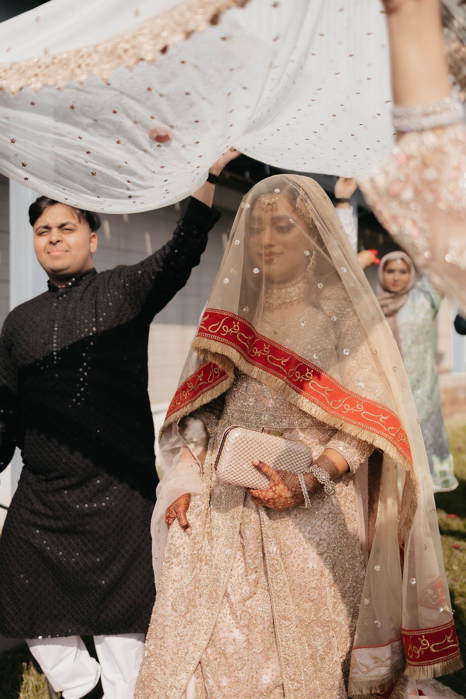 Traditional South Asian wedding ceremony with bride under decorated white canopy.