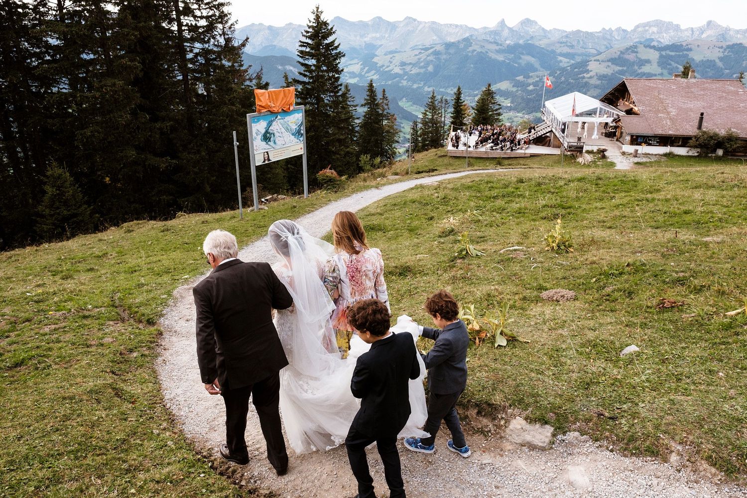 TLOOK photographe de mariage de style documentaire, Wasserngrat à Gstaad cérémonie sur la terrasse arrivée de la mariée avec ses parents
