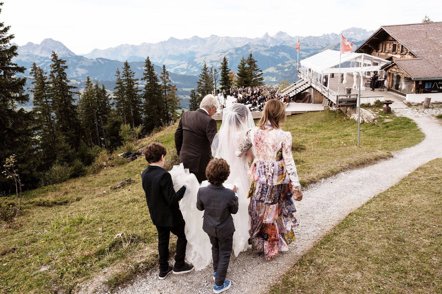 TLOOK photographe de mariage de style documentaire, Wasserngrat à Gstaad cérémonie sur la terrasse arrivée de la mariée avec ses parents