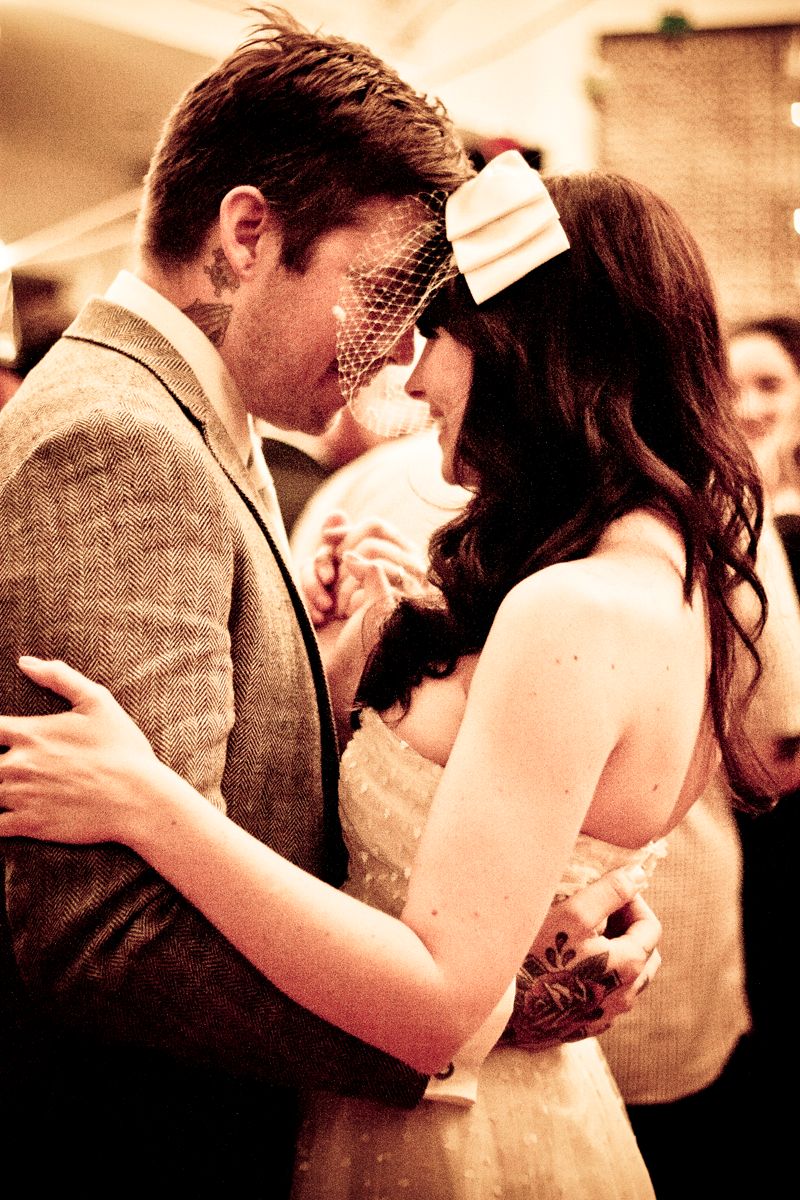 A romantic wedding moment with a vintage filter showing a couple embracing while the bride wears a delicate veil.