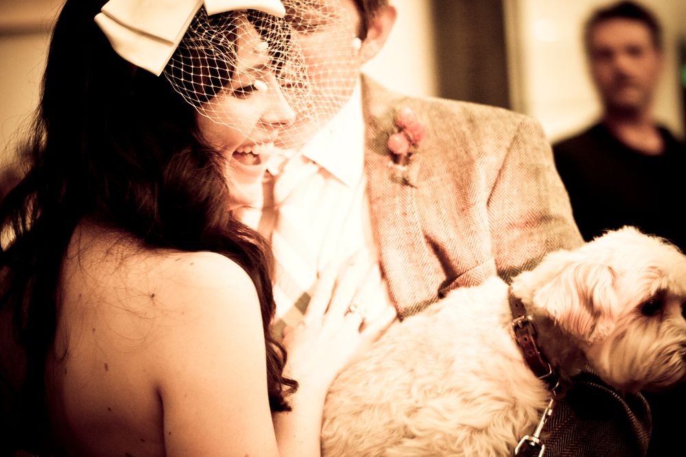 A sepia-toned wedding photo capturing an intimate dance moment with the bride wearing a vintage veil.