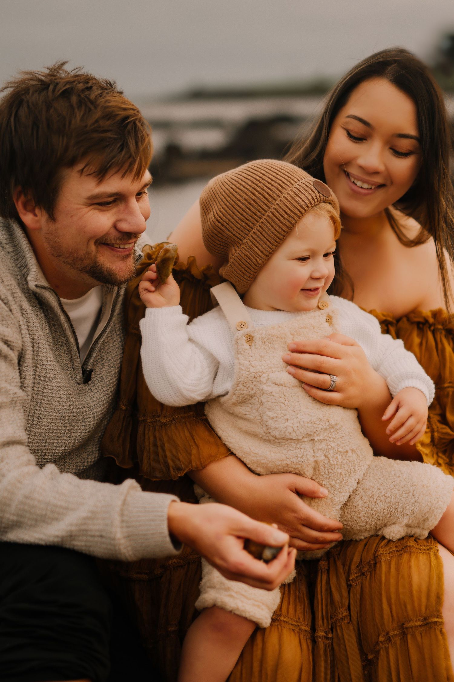 A joyful family moment captured at sunset against a coastal backdrop.