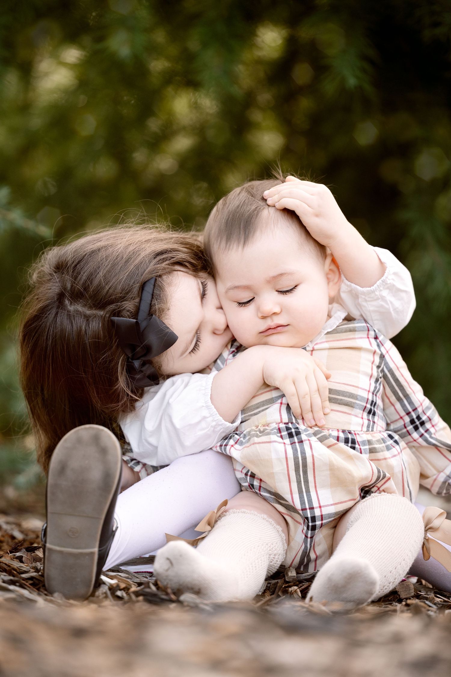 Tender outdoor photo session showing two children resting on autumn leaves.