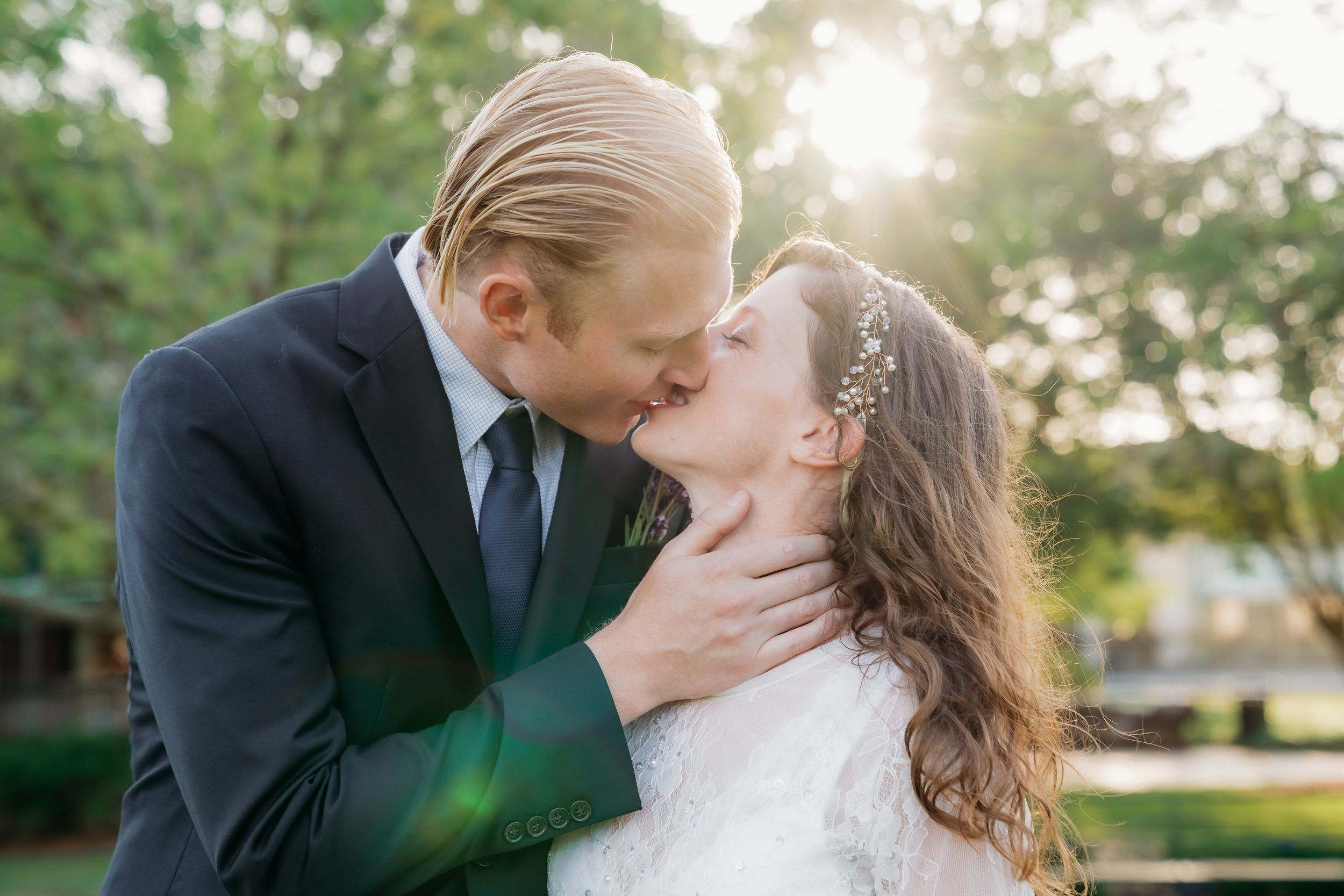 A groom kisses his bride inside of Jackson Square, in the French Quarter, as the sun rises behind them.