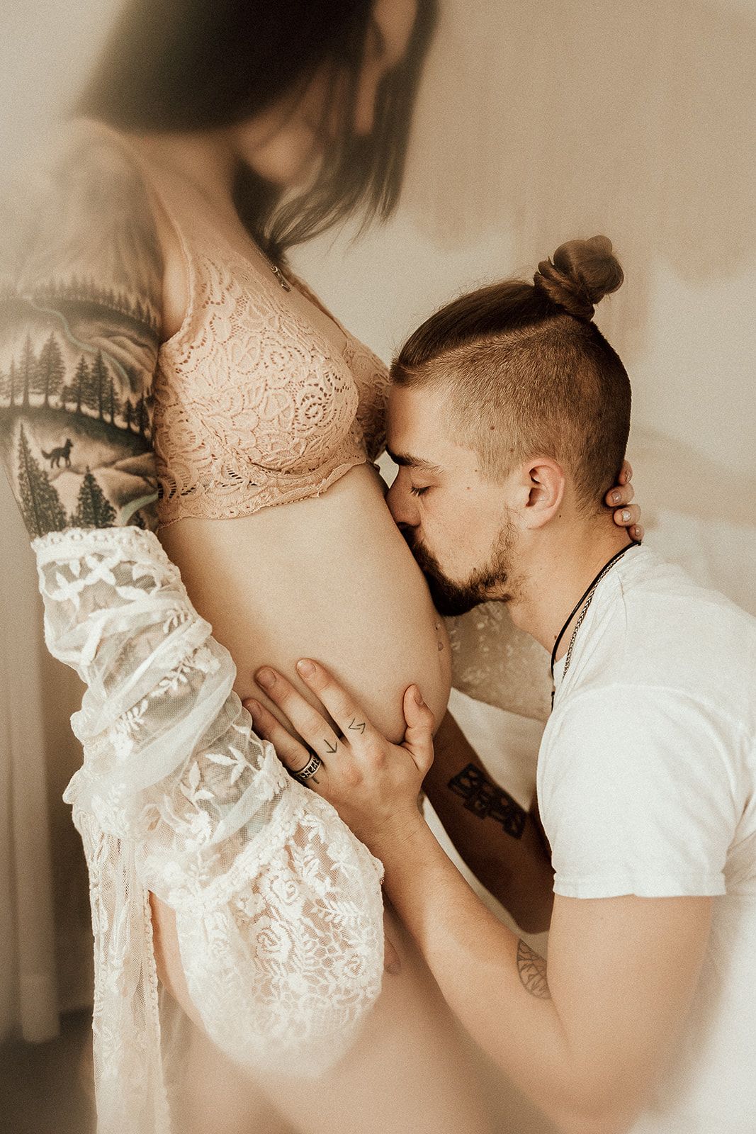 A father kisses his wife's pregnant baby belly during their Charlottesville Maternity session.