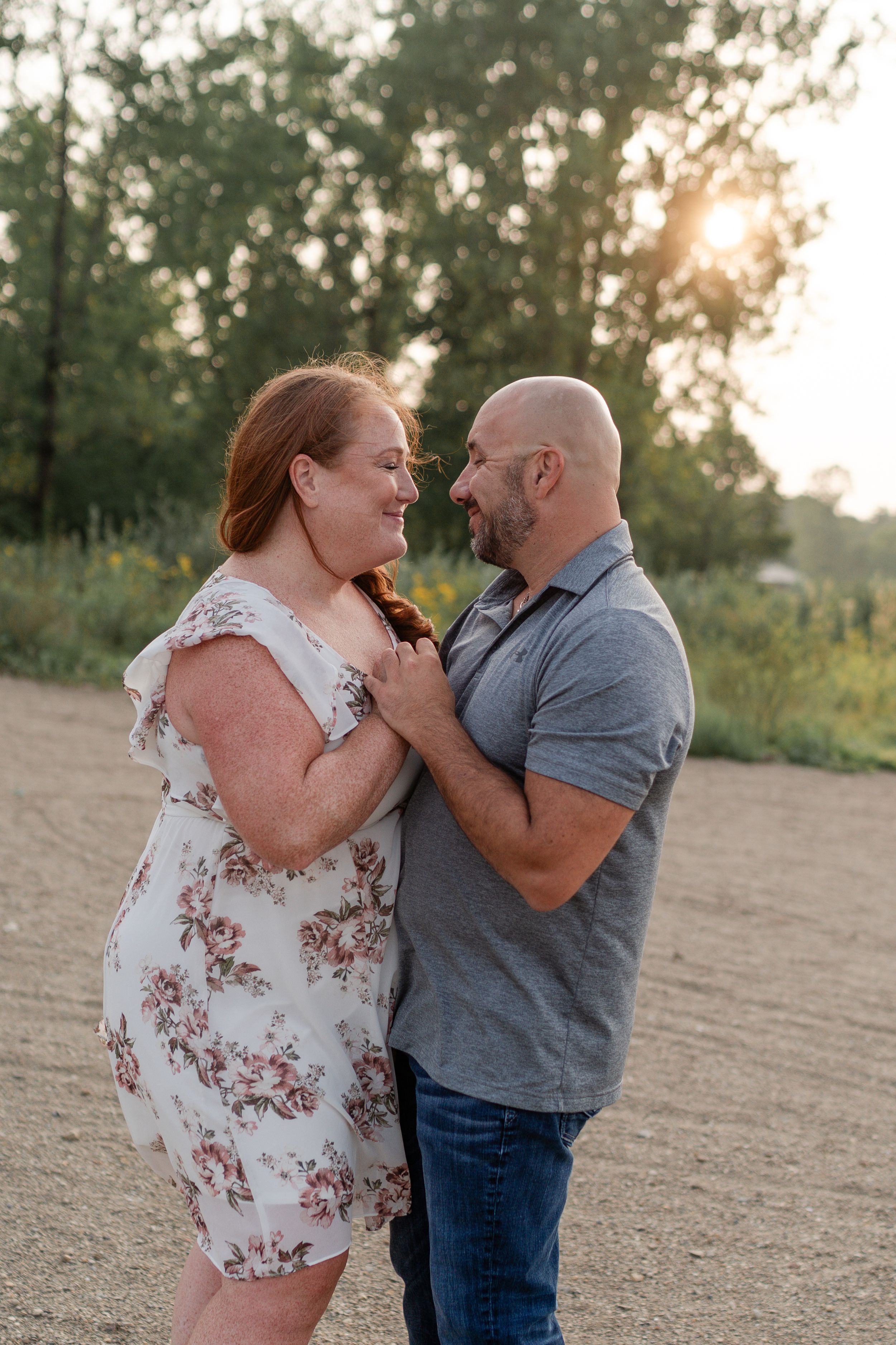 Couple sharing tender moment at sunset in outdoor setting.