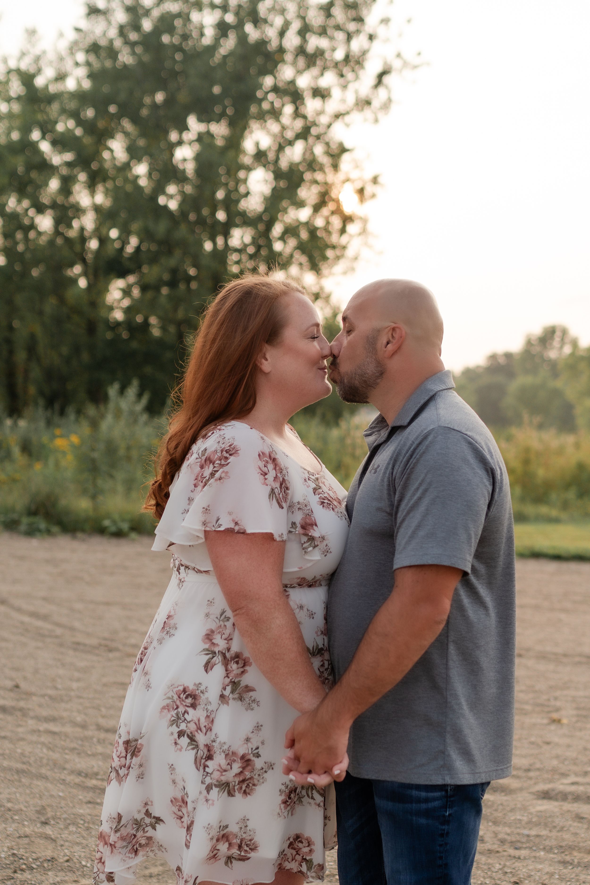 Intimate moment between couple during sunset engagement session.