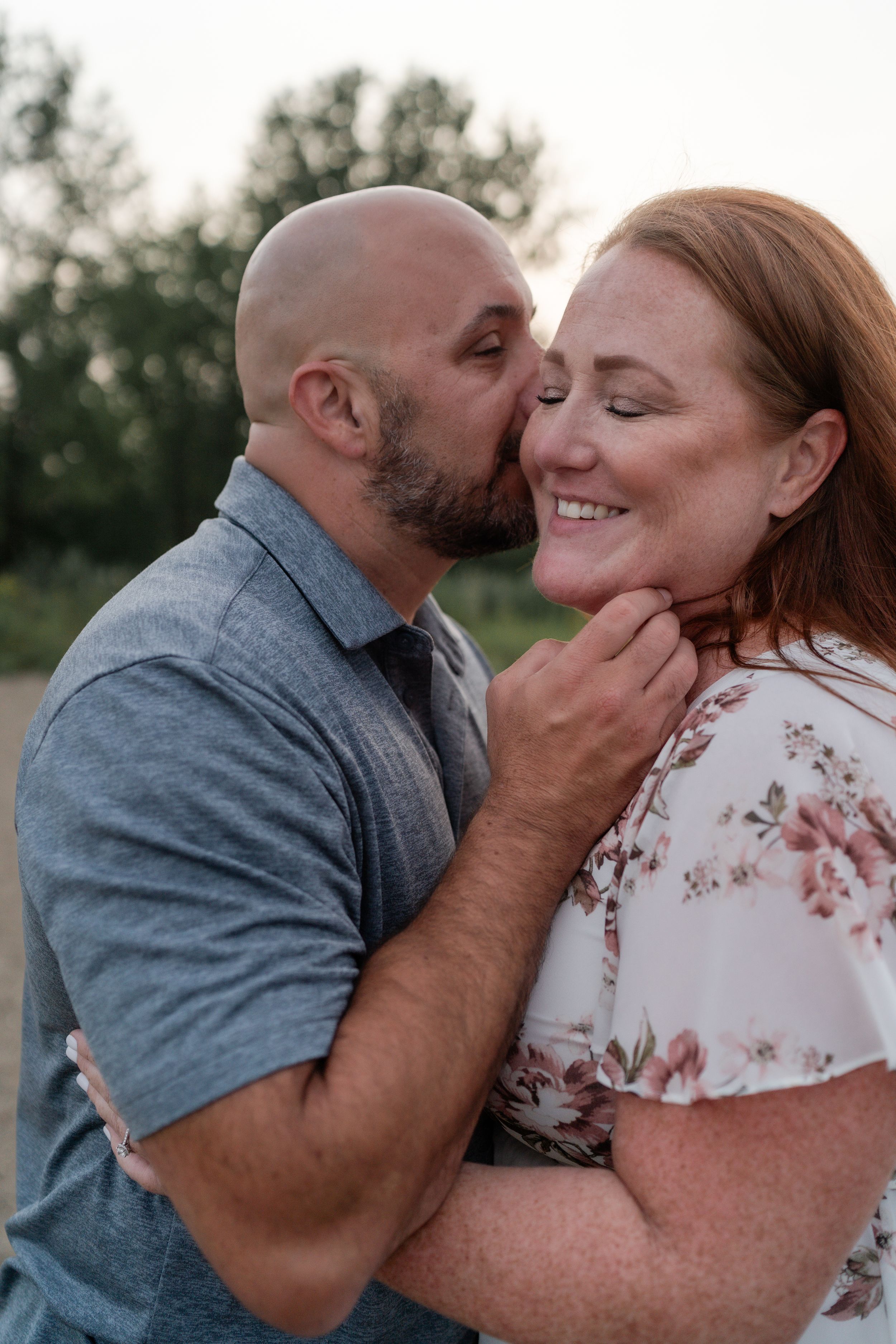 Joyful couple sharing affectionate moment outdoors during golden hour.